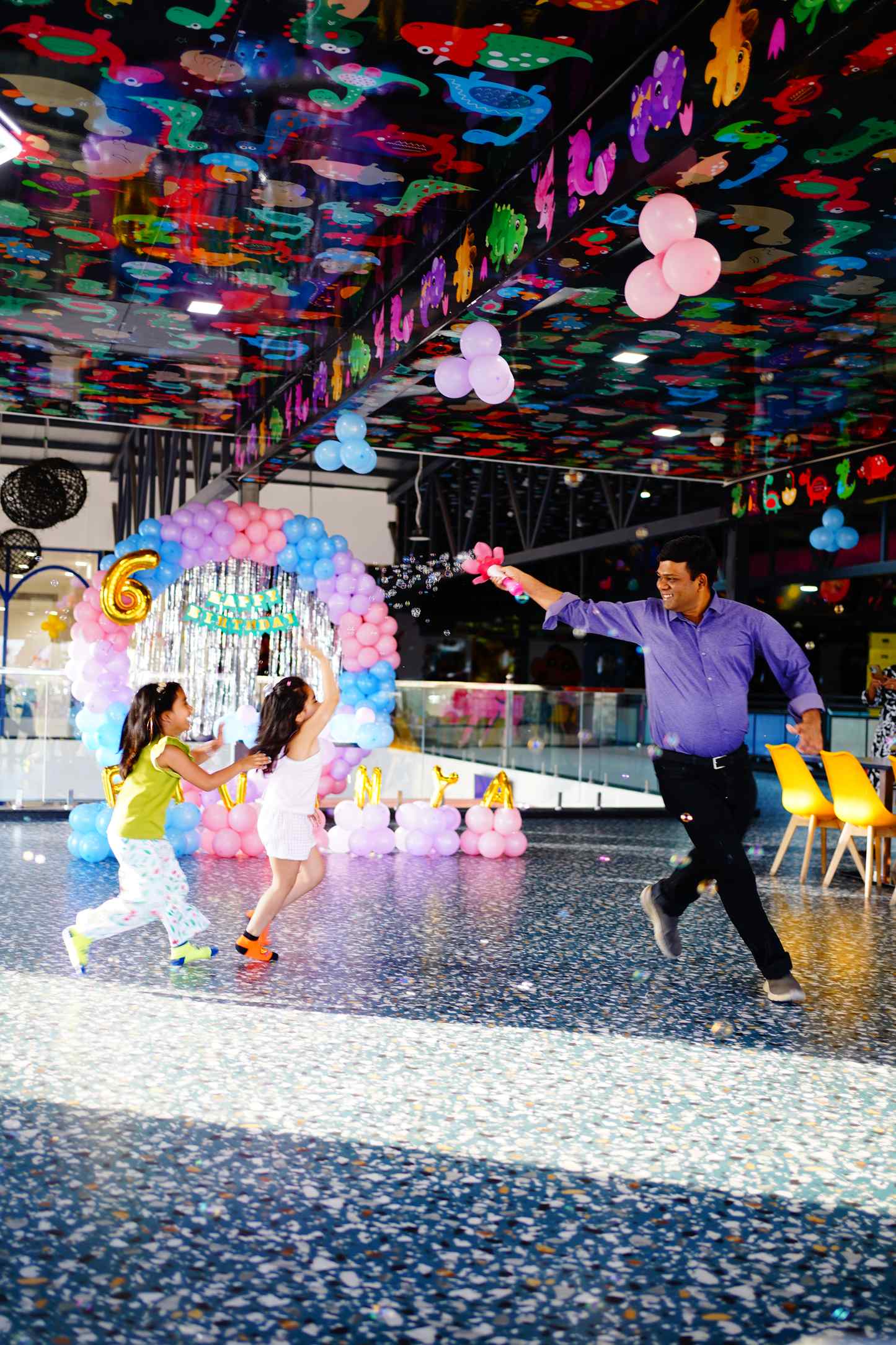 A father running with the children across the decorated hall