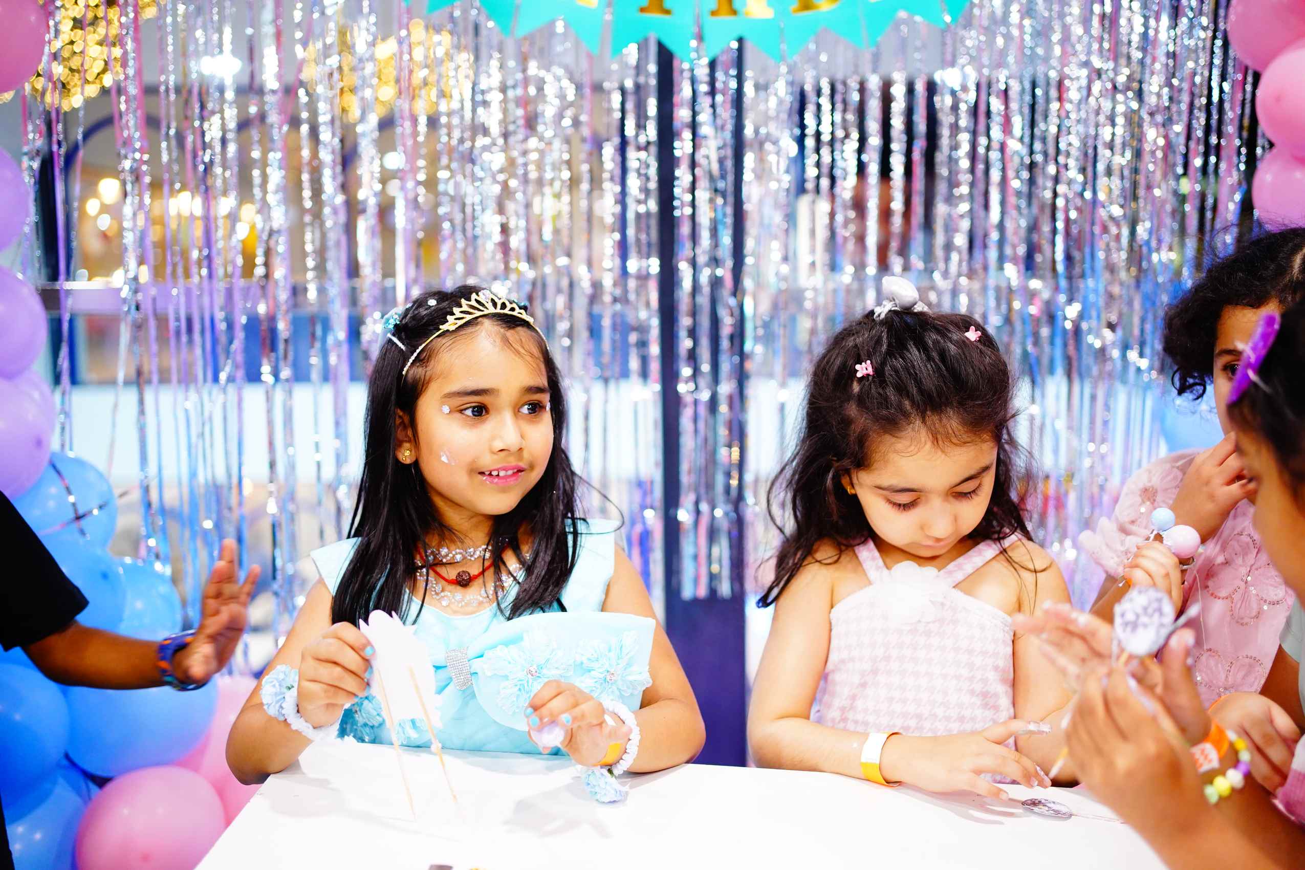 Two girls opening gifts at the party table