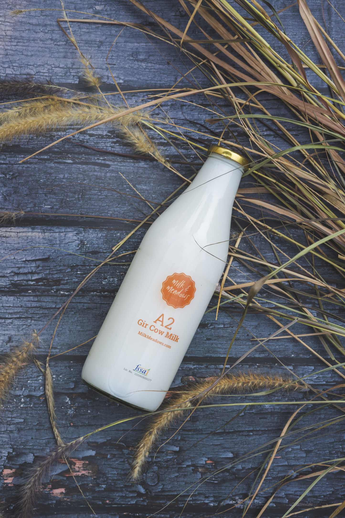 A2 Gir cow milk bottle laid on weathered wooden planks