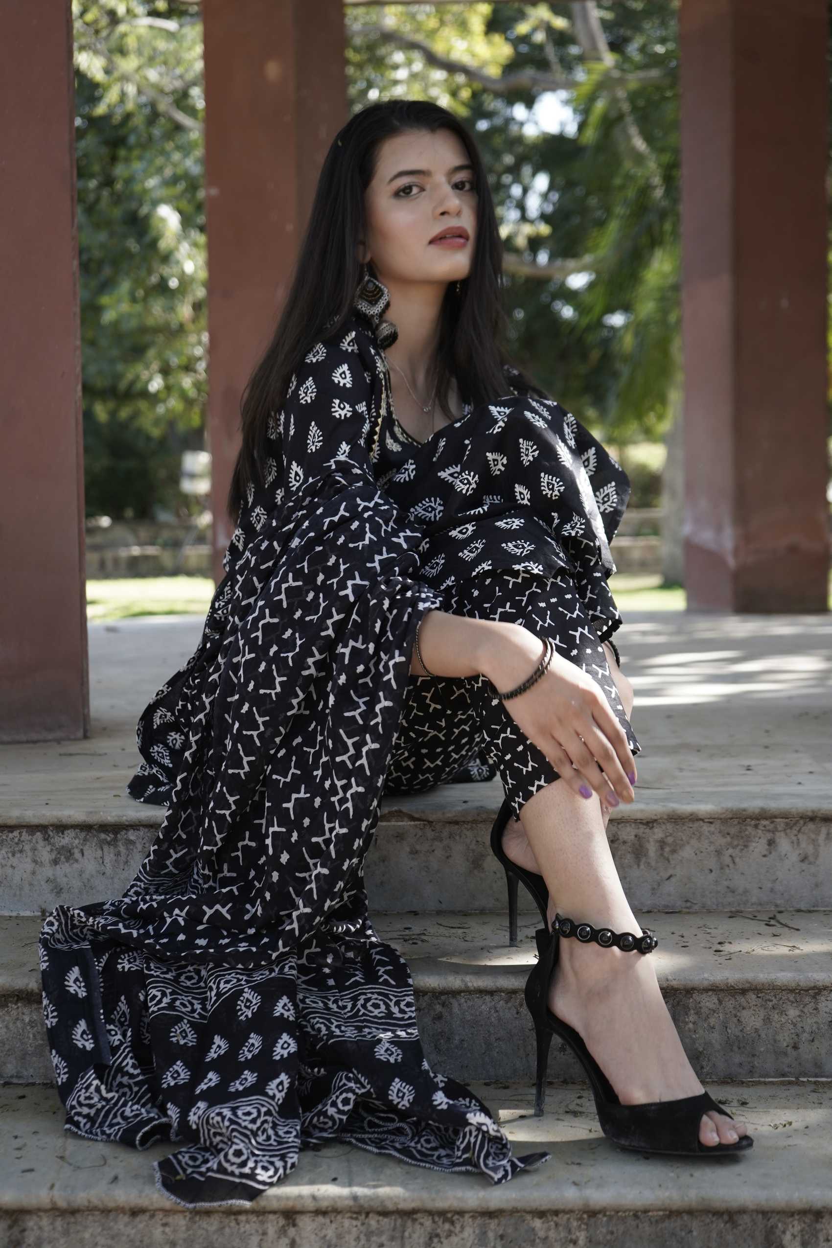 A woman in a black printed dress on the colonnade steps