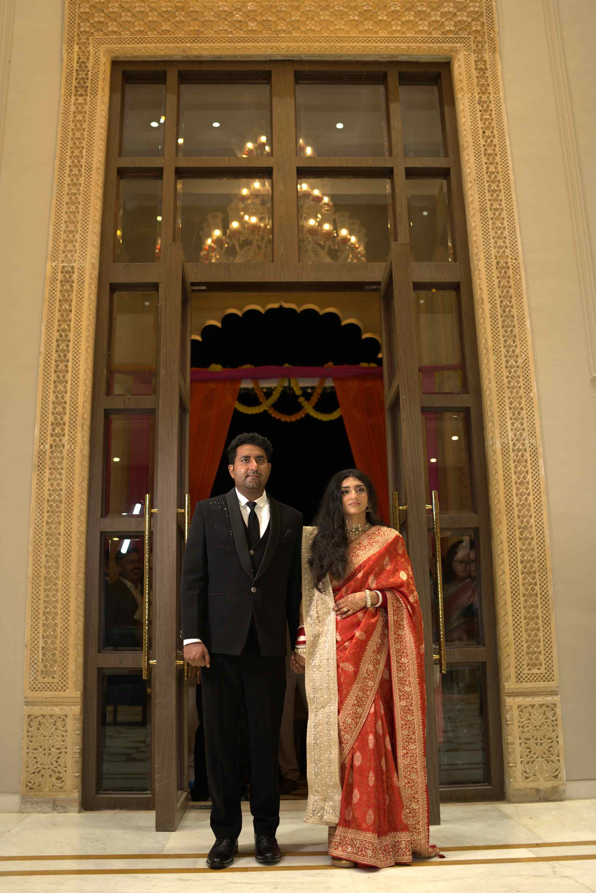 The couple at the palace entrance, the doors open behind them