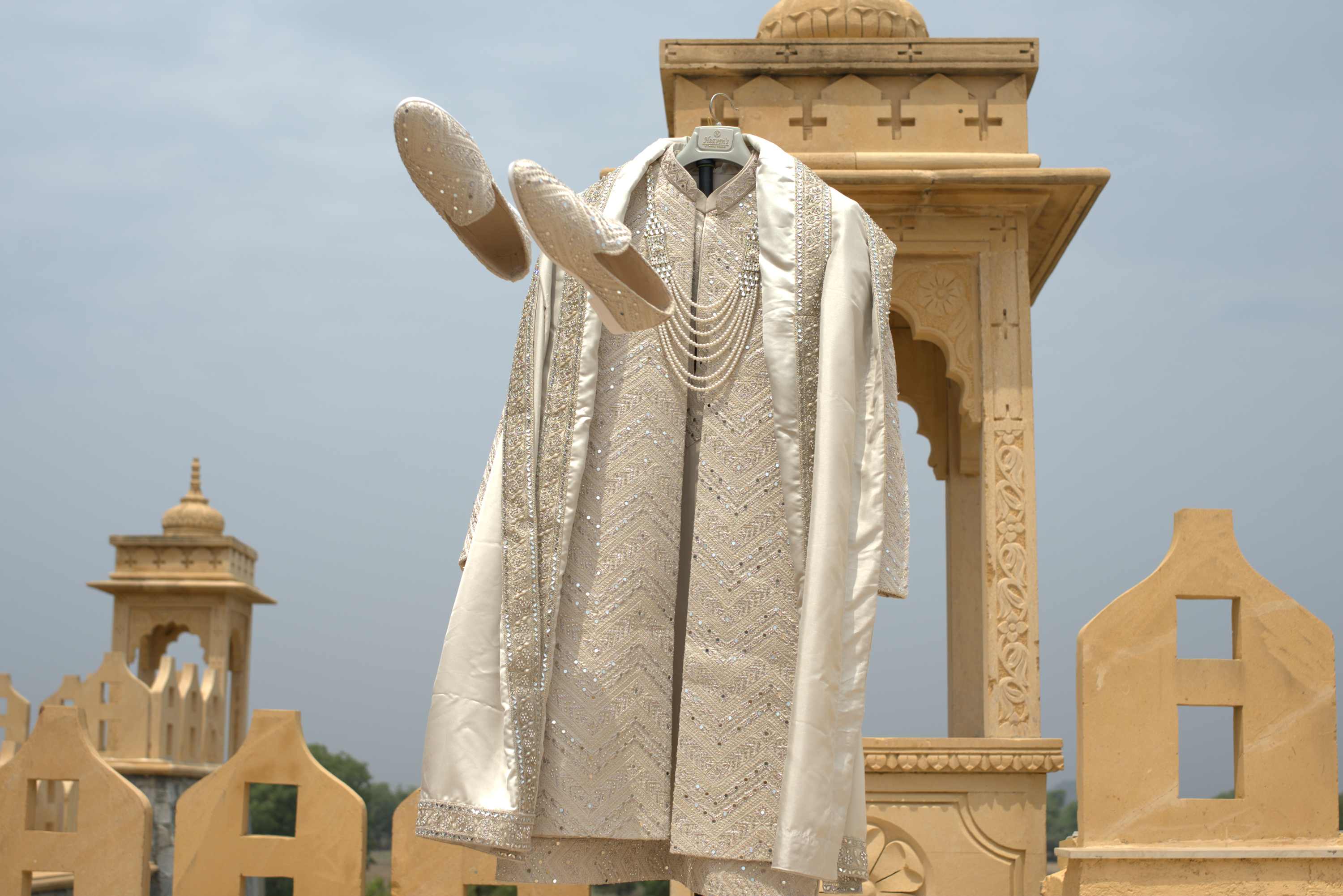 The groom's sherwani hanging on the palace terrace, the city below