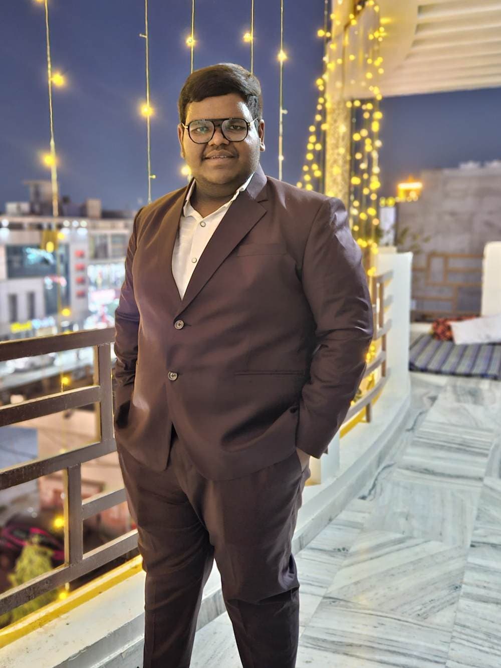 Krishna Bansal on a terrace strung with lights, before a night flight