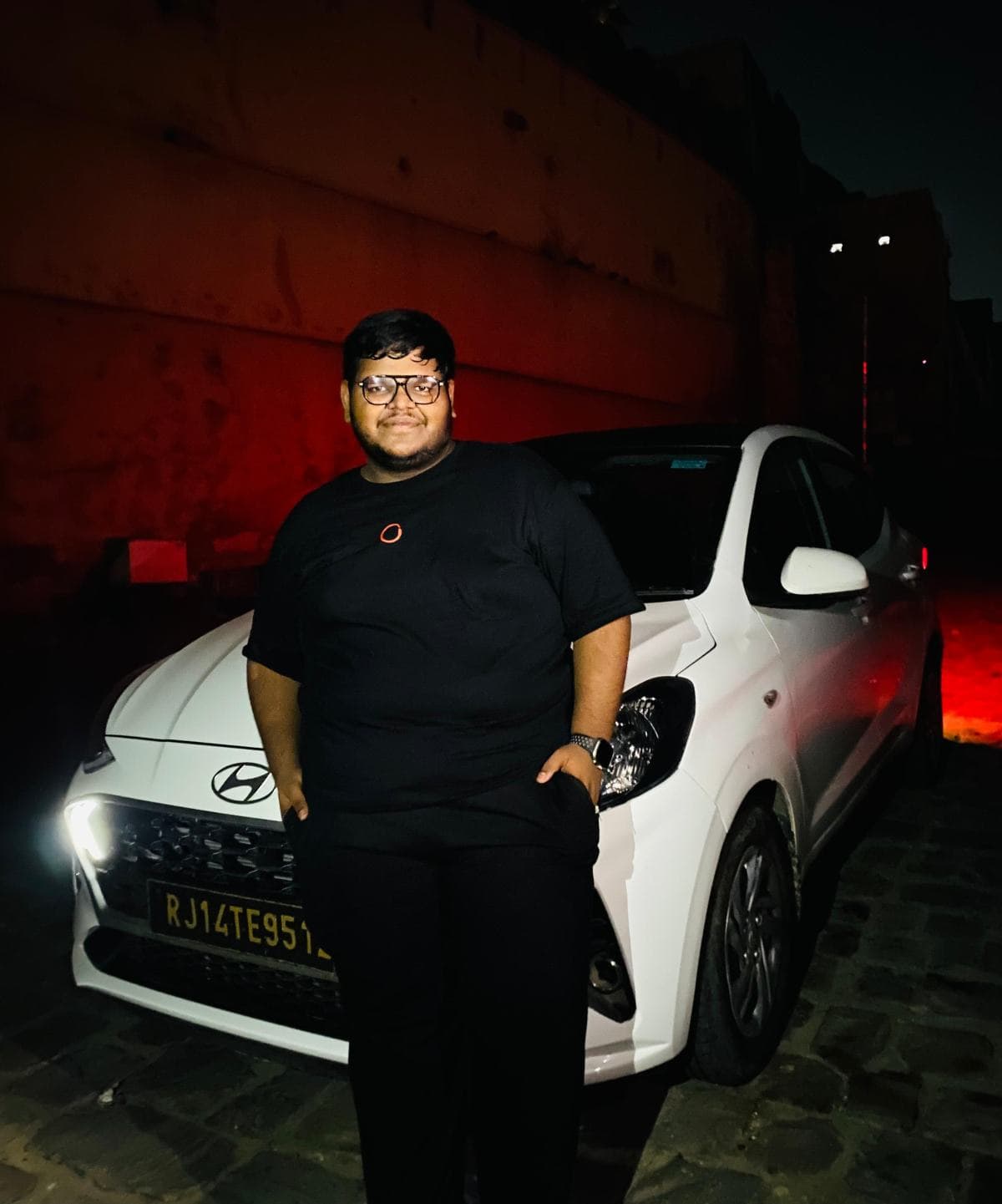 Krishna Bansal beside the car at night, on the way to a job