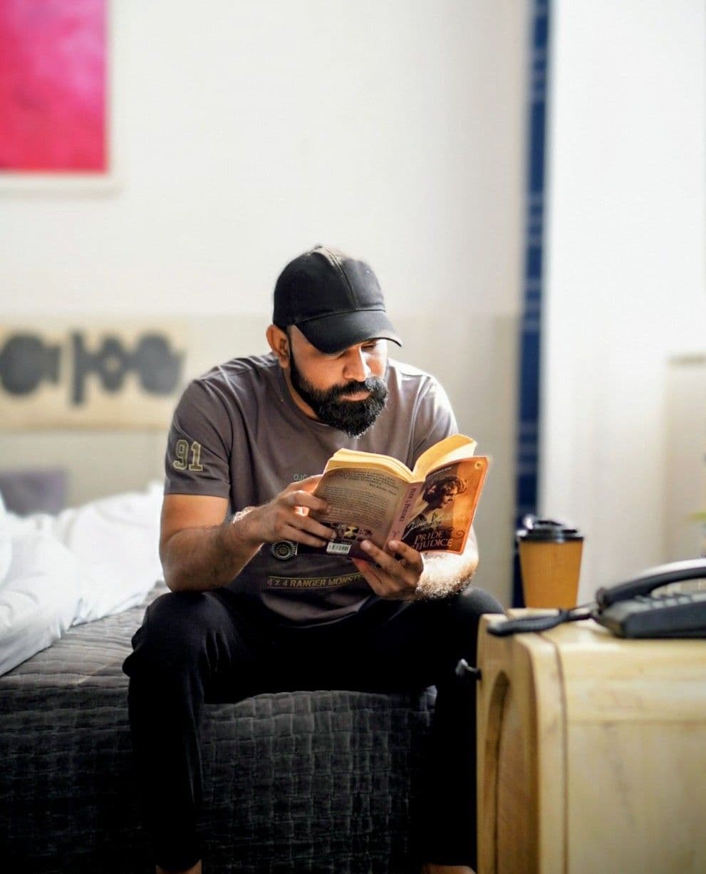 Rohit Likhala reading, kit on the table beside him