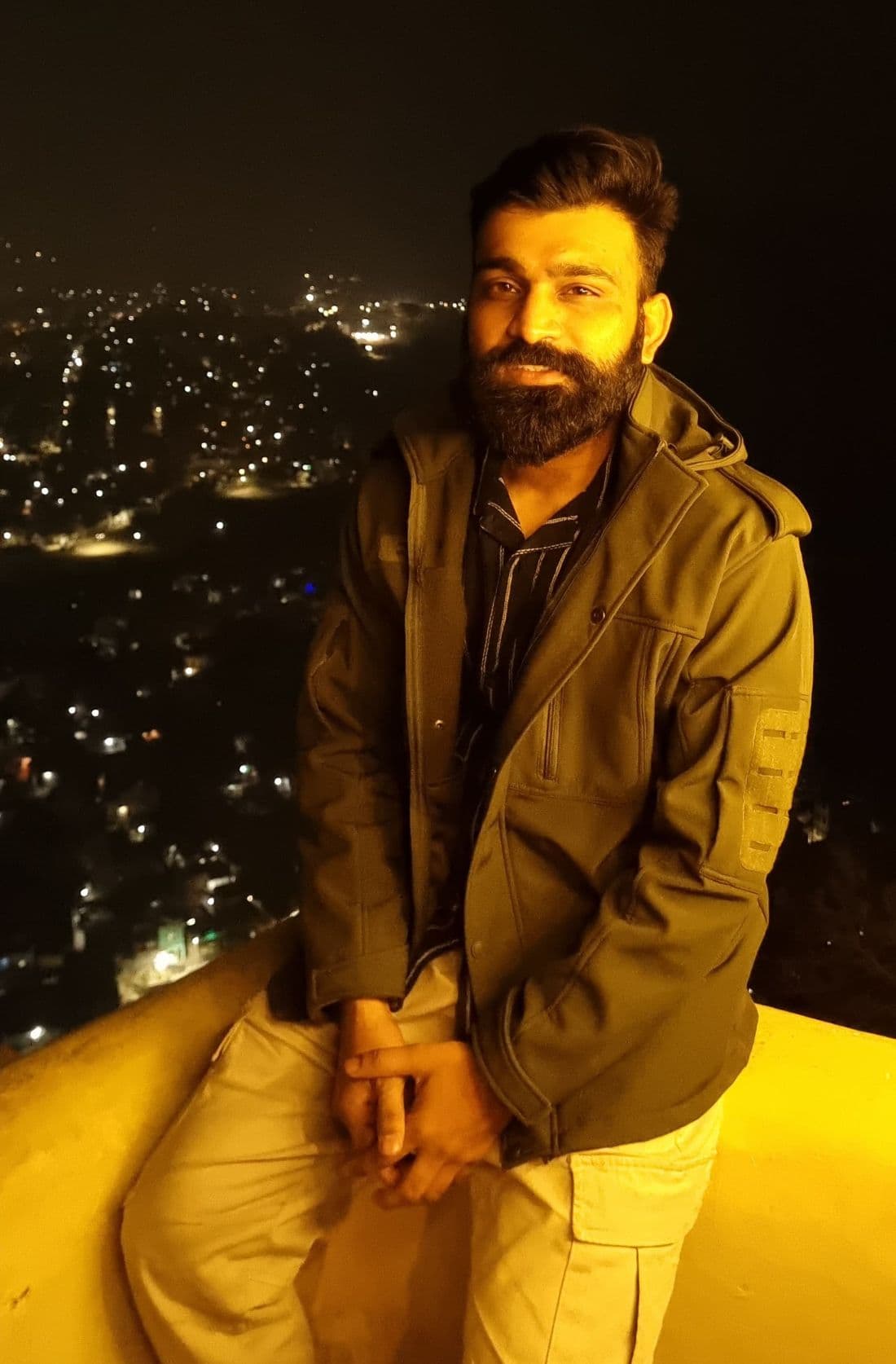 Rohit Likhala on a rooftop above the city lights