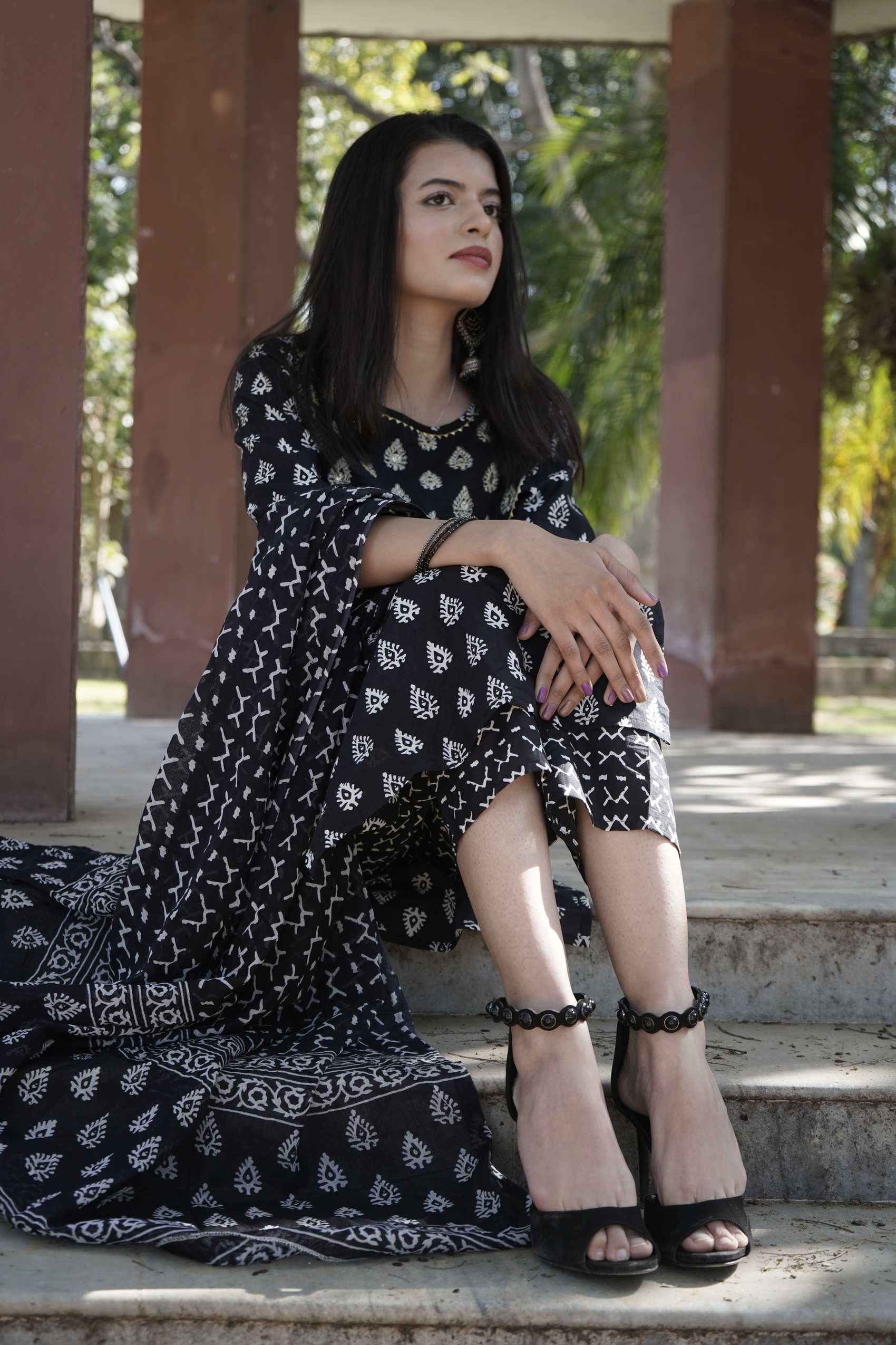 The same look, seated on the steps between the pillars